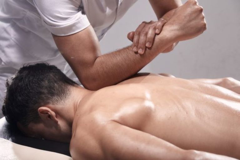 Rückenmassage Ein Mann genießt eine Rückenmassage